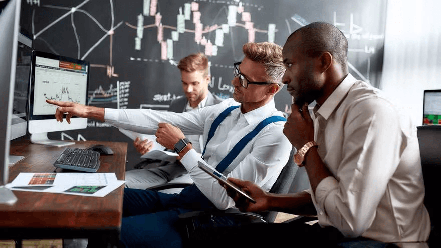 Three businessmen analyzing financial charts